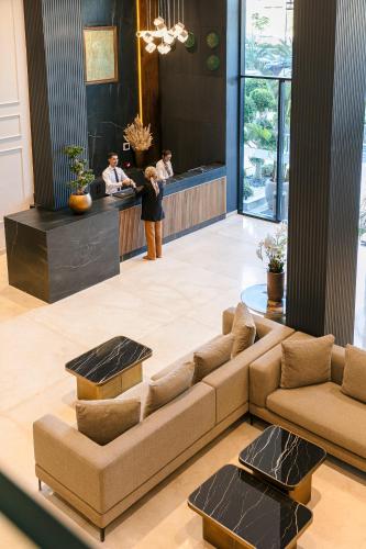 a living room with a couch and people standing in a kitchen at NearYo Hotels in Marrakech