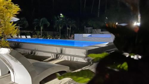 a swimming pool at night with benches and a swimming pool at Aloha Seaside Resort in Siquijor
