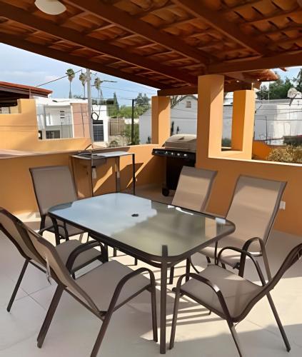 a patio with a glass table and chairs on a balcony at Cheerful residential house in the heart of Chapala in Chapala