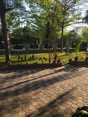 a park with benches and trees in the shade at Guestmate Inn in Livingstone