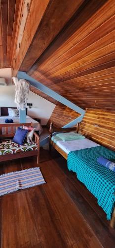 two beds in a room with a wooden ceiling at MANDALA DREAMS Pousada e Portal Holístico in Maceio
