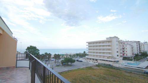 a balcony with a view of a building and the ocean at Appartamenti sul lungomare in Alba Adriatica