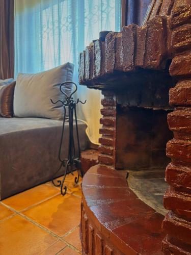 a tripod in a living room with a brick fireplace at Villa Authentique avec Vue Panoramique à 3 km de Chefchaouen in Chefchaouene
