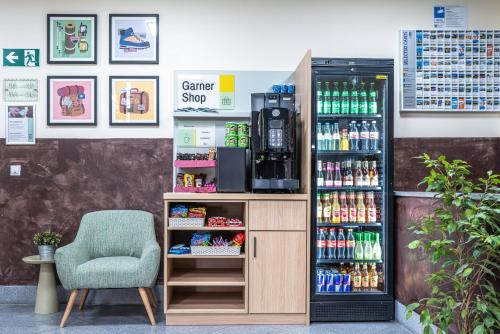 Una estación de bebidas con una silla y una máquina expendedora. en Garner Hotel Munich - Messe by IHG, en Haar