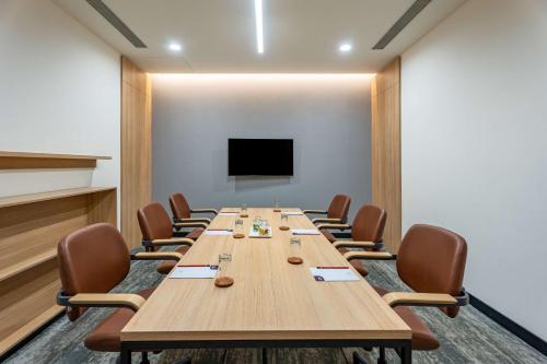a conference room with a long table and chairs at Park Inn & Suites by Radisson Thrissur East Fort in Trichūr