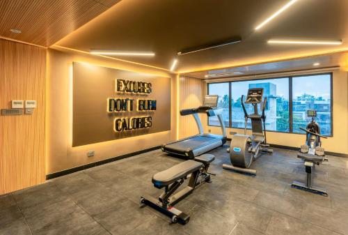 a gym with treadmills and exercise equipment in a building at Park Inn & Suites by Radisson Thrissur East Fort in Trichūr