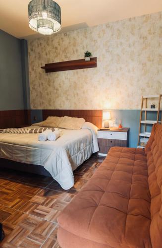 a hotel room with two beds and a couch at Habita Sucre in Sucre