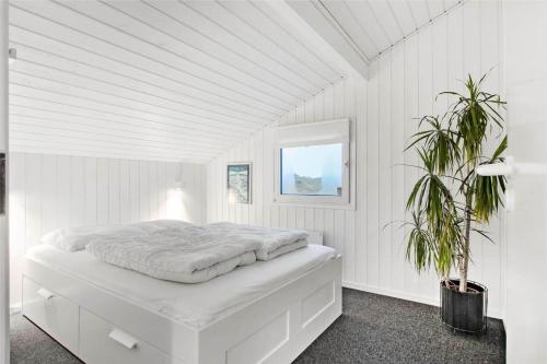 a white bedroom with a white bed with a plant at LN1791-Hjorring-Hongardsvej-1 in Hjørring