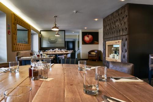 a wooden table in a restaurant with glasses on it at The Queens Head in Belton