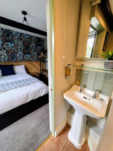 a bathroom with a sink and a bed and a mirror at The Old Mill Hotel in Salisbury