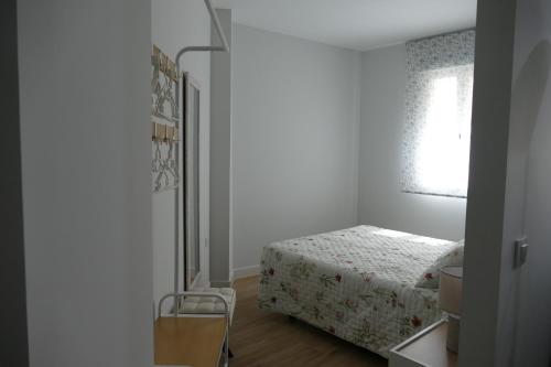 a small bedroom with a bed and a window at Apartamento Fama in Cáceres