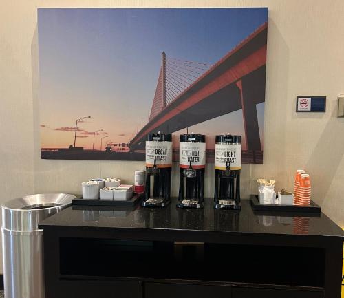 a counter with three bottles of coffee on it with a bridge at Comfort Inn & Suites Toledo North in Toledo