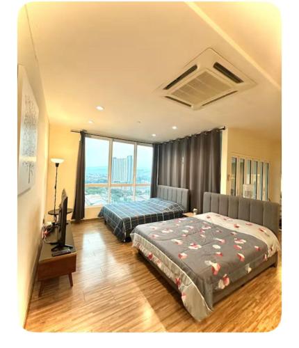 a bedroom with two beds and a television in it at Setapak Central Mall Bathtub & Netflix in Kuala Lumpur