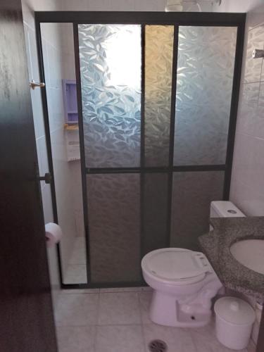 a bathroom with a shower with a toilet and a sink at Edificio Residencial Vista Praia in Mongaguá