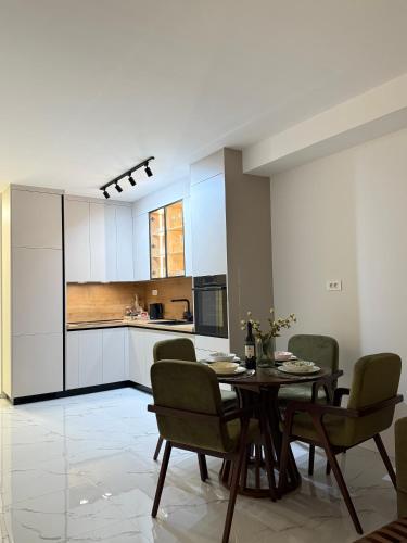 a kitchen and dining room with a table and chairs at Apartman Dukat- Luksuzna novogradnja u srcu Vinkovaca s parkingom in Vinkovci