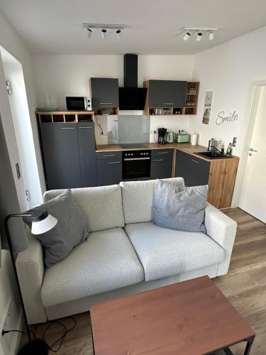 Una sala de estar con un sofá y una cocina. en Sylt-Apartment, en Hannover