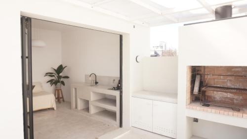 a white room with a glass door and a table at PH en La Plata con terraza in La Plata