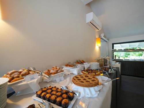 een buffet met veel verschillende soorten gebak en taarten bij Le Dune Resort in Menfi