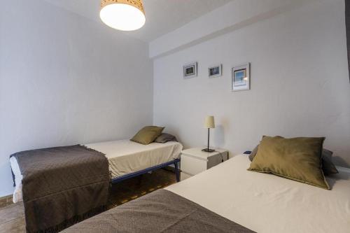 トレ・デル・マールにあるSea View & Beach View Appartement Torre Del Marのベッド2台とランプが備わる部屋