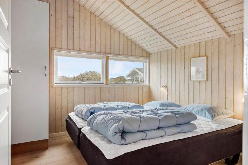 una camera da letto con un letto grande con cuscini blu di LN1816-Hjorring-Rodspaettevej-14 a Hjørring