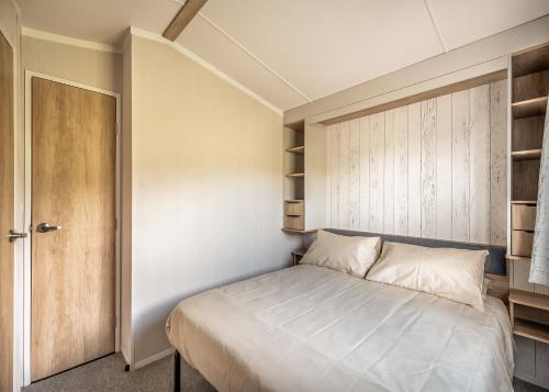 a small bedroom with a bed and a closet at Kippford View Holiday Park in Castle Douglas
