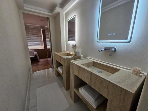 een badkamer met twee wastafels en een grote spiegel bij Residence L Heritage Tennyson in Mexico-Stad