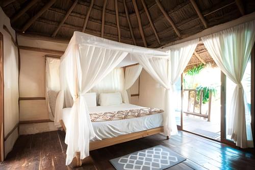un dormitorio con una cama con dosel en Stunning 6 Private Villas & PH /Wifi/AC/Pool/Gym., en Tulum