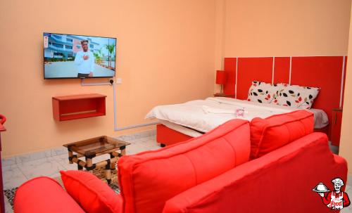 a living room with a red couch and a bed at Kijana Msafi Hotel Nyahururu in Nyahururu