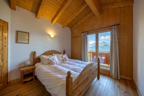 Un dormitorio con una cama y una ventana grande en Chalet Chocolat - Great view, en Nendaz