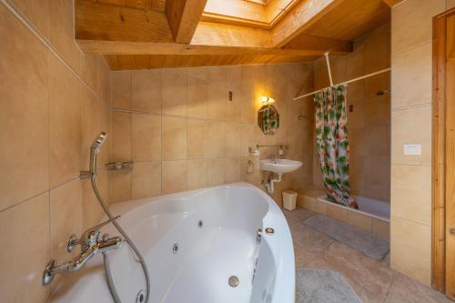 Un baño con bañera blanca y lavabo. en Chalet Chocolat - Great view, en Nendaz