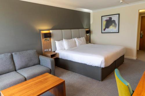 a hotel room with a bed and a couch at Holiday Inn Newcastle Gosforth Park by IHG in Newcastle upon Tyne