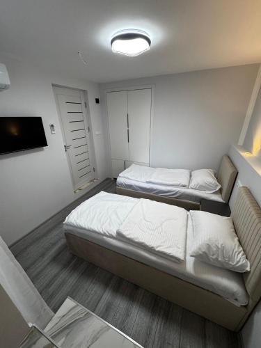 a small room with two beds and a television at Station House EVN in Yerevan