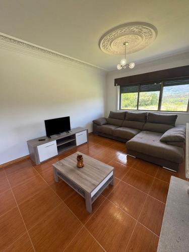 a living room with a couch and a tv at House Santiago in Ponte de Lima in Ponte de Lima