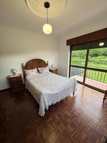 a bedroom with a bed and a large window at House Santiago in Ponte de Lima in Ponte de Lima