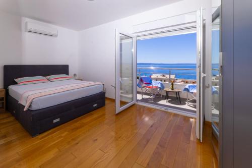 a bedroom with a bed and a view of the ocean at Apartments Sanela in Veliko Brdo