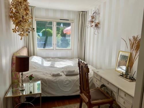 a bedroom with a bed and a desk and a window at Beautiful rooms in a charming Båstad villa top location near the beach and town center in Båstad
