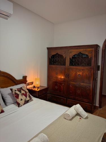a bedroom with a bed with a wooden dresser at Villa Authentique avec Vue Panoramique à 3 km de Chefchaouen in Chefchaouene
