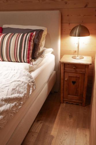 a bedroom with a bed and a lamp on a night stand at The Mazot in Nendaz