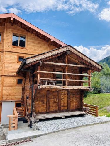 a large wooden cabin with a porch at The Mazot in Nendaz