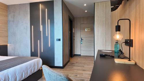 a bedroom with a bed and a desk with a lamp at Hotel Focus in Pas de la Casa