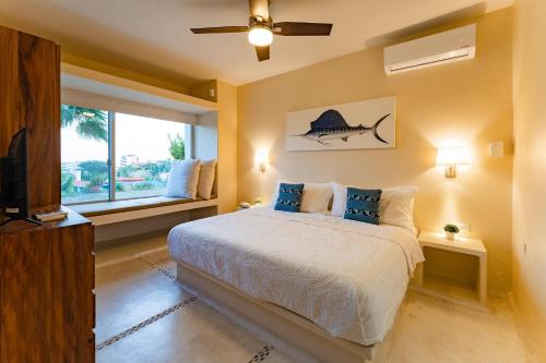 a bedroom with a bed with blue pillows and a window at 1004 - Bella Vista in Santa Cruz Huatulco