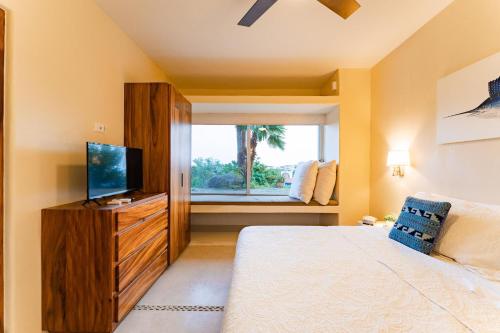 a bedroom with a bed and a tv and a window at 1004 - Bella Vista in Santa Cruz Huatulco