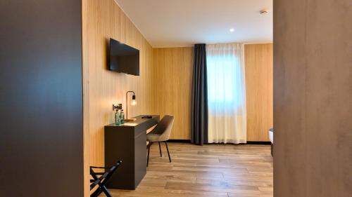 a hotel room with a desk and a television on a wall at Hotel Focus in Pas de la Casa