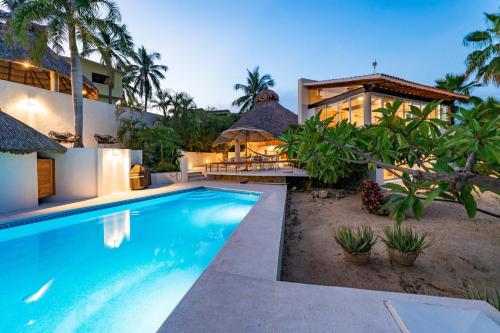 a villa with a swimming pool and a house at 1004 - Bella Vista in Santa Cruz Huatulco