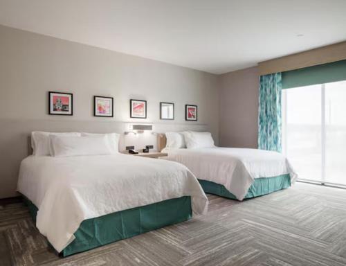a hotel room with two beds and a window at Hilton Garden Inn Merced in Merced