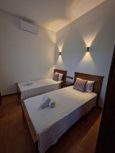two beds in a room with white walls and lights at Villa Authentique avec Vue Panoramique à 3 km de Chefchaouen in Chefchaouene