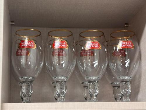 four empty wine glasses sitting on a shelf at Breeze Blows House, Incheon in Towŏn-yŏk