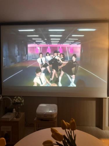 a tv screen with a group of people on it at Breeze Blows House, Incheon in Towŏn-yŏk