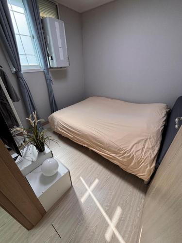 a small bedroom with a bed and a table at Breeze Blows House, Incheon in Towŏn-yŏk