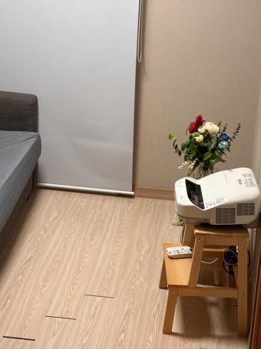 a room with a fax machine and flowers on a table at Breeze Blows House, Incheon in Towŏn-yŏk